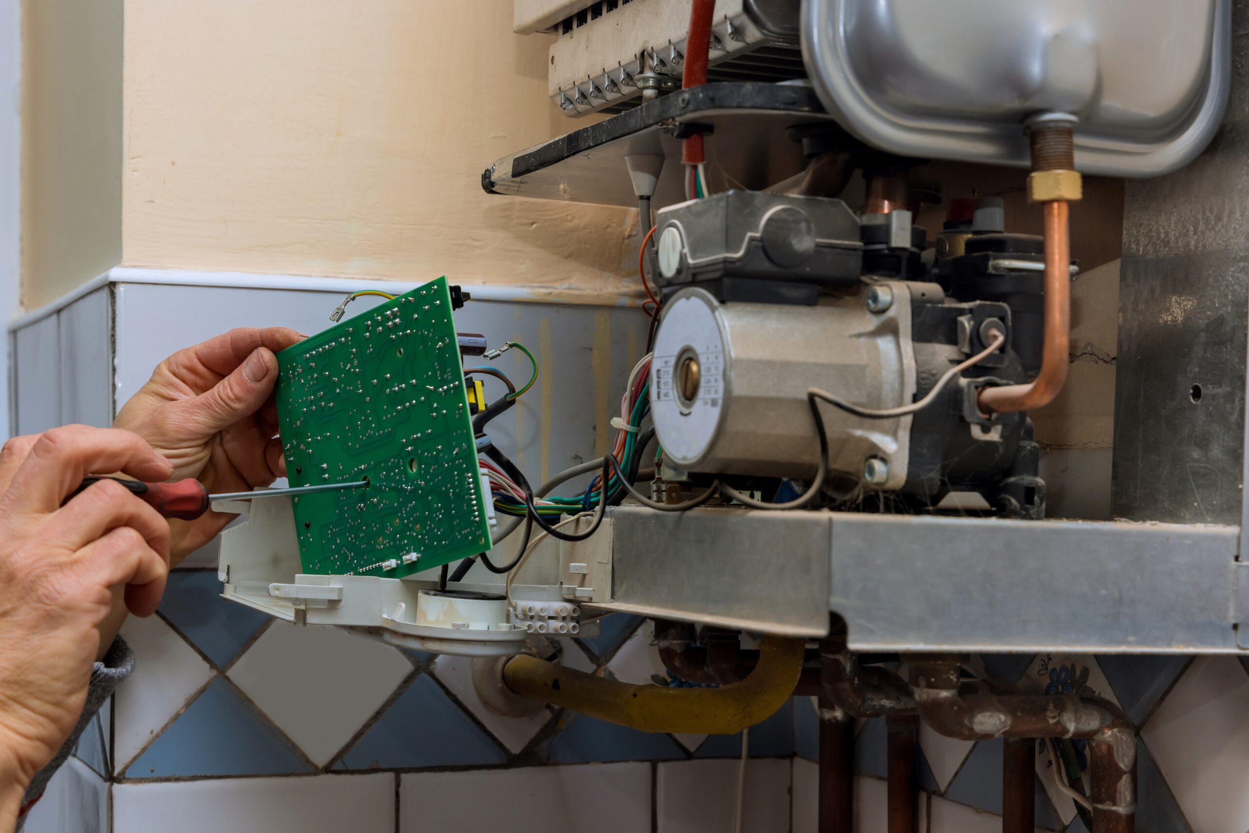 Technician worker looking inside gas heater trying to fix the problem